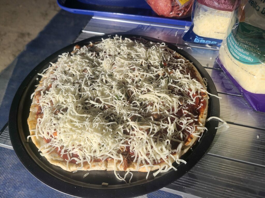 Top the Pizza on the Blackstone Griddle with more cheese