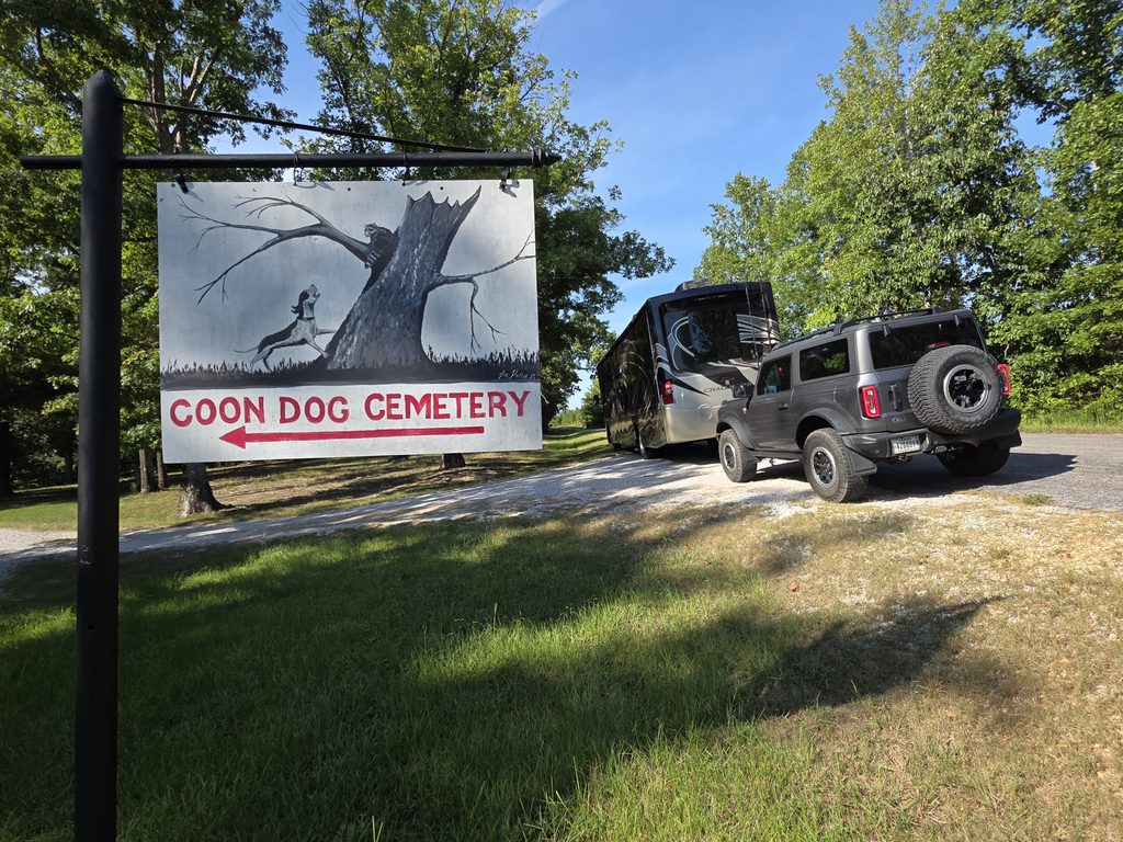 Our motorhome and toad in front of the Coon Dog Cemetery Sign.