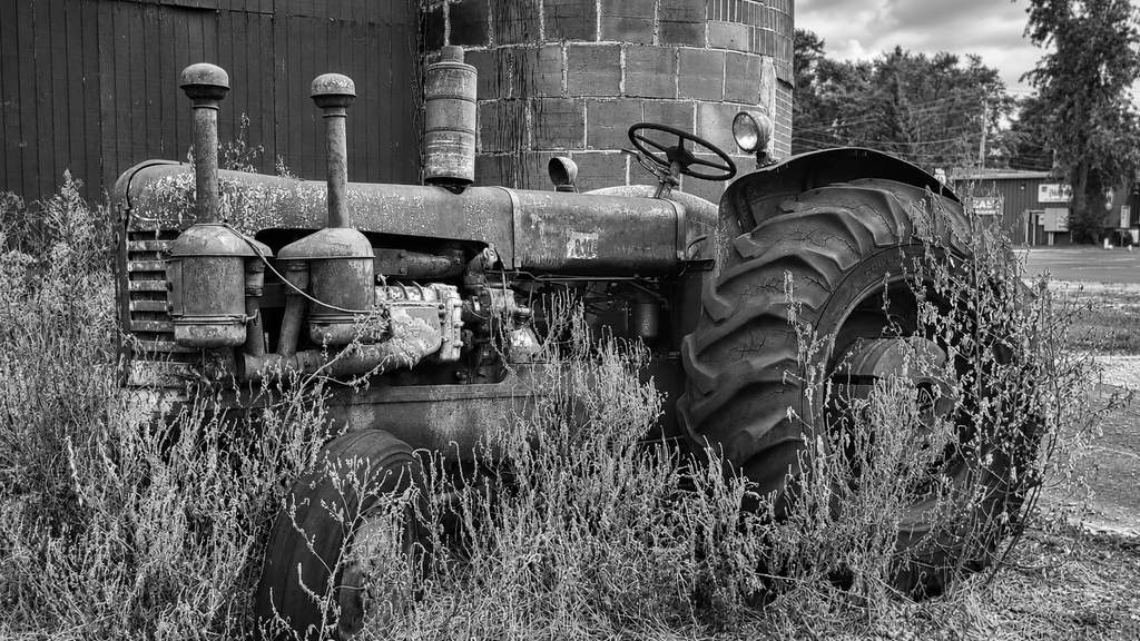 Weathered antique tractor beside the Cammack grain elevator